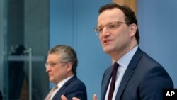 German Health Minister Jens Spahn, right, and Lothar H. Wieler, president of the Robert-Koch-Institute, address the media during a press conference in Berlin, Germany, Feb. 19, 2021.