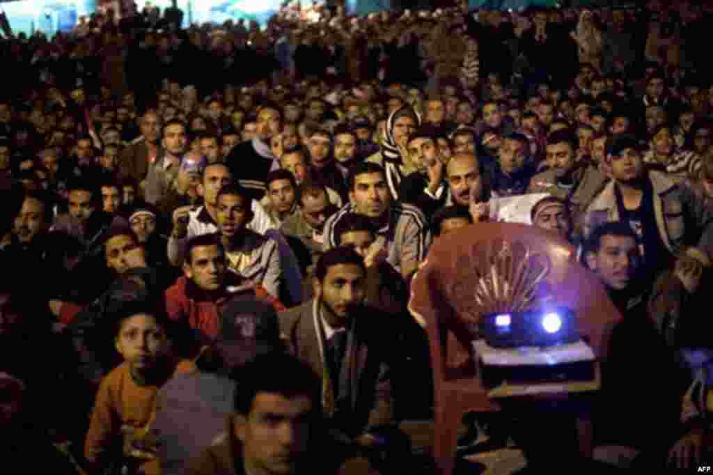 Anti-government protesters watch on a big screen as Egyptian President Hosni Mubarak makes a televised statement to his nation in Tahrir Square in downtown Cairo, Egypt Thursday, Feb. 10, 2011. (AP Photo/Emilio Morenatti)