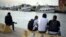 FILE - Unaccompanied minors from north Africa sit by the river Tiber, in Fiumicino, Italy, 30 kilometers (19 miles) west of Rome, April 21, 2016.