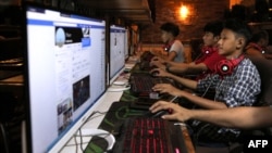 FILE - This picture taken on Dec. 18, 2018 shows Myanmar youths browsing their Facebook page at an internet shop in Yangon.