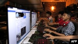 FILE - This picture taken on Dec. 18, 2018 shows Myanmar youths browsing their Facebook page at an internet shop in Yangon.