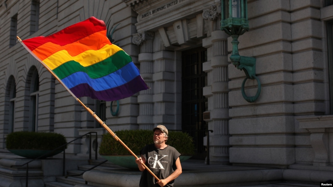 Bob Sodervick melambaikan bendera pelangi di luar pengadilan di San Francisco, California, menuntut pengakuan pernikahan sejenis (Foto: Dok)
