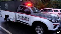 ARCHIVO - Vehículos policiales utilizados para transportar cadáveres salen de la comunidad cerrada donde se estrelló un avión en Vinhedo, estado de Sao Paulo, Brasil, el sábado 10 de agosto de 2024.