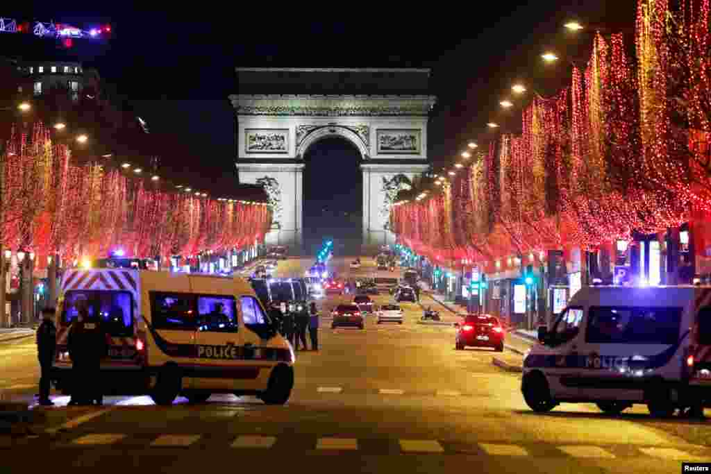 French police patrol on the Champs Elysees avenue in Paris after celebrations and gatherings have been banned due to COVID-19 restrictions in France, Dec. 31, 2020.