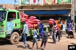 FILE- Bags of rice are offloaded from a truck at Niamey's main market on August 8, 2023. Aid groups are concerned that supplies in Niger will run out if the political instability continues. (Photo by AFP)