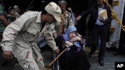 Un rebelle libyen aidant une femme évacuée de Misrata à bord du ferry alabanais Red Star 1 et débarquant au port de Benghazi, 28 avril 2011.