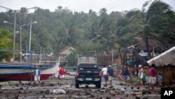 Debris litter the road by the coastal village in Legazpi city following a storm surge brought about by powerful Typhoon Haiyan in Albay province, Nov. 8, 2013, about 520 kilometers ( 325 miles) south of Manila, Philippines. 