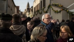 FILE - People taste wine during an annual rite known as the Saint Vincent Tournante, in Saint-Aubin, central France, January 2014.