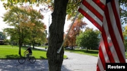 FILE - A bicyclist rides through a neighborhood in Saginaw Township, Michigan, October 10, 2019. 