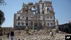 Houthi Shiite rebels walk amid the rubble of the Republican Palace that was destroyed by Saudi-led airstrikes, in Sanaa, Yemen, Dec. 6, 2017.