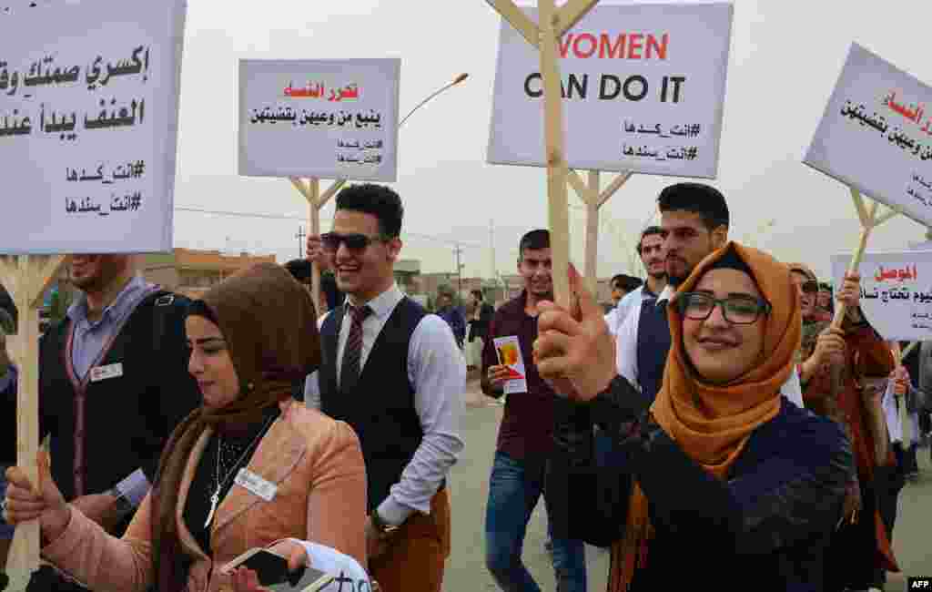 Des jeunes irakiennes participent à la marche de la Journée des droits des femmes dans l'ancienne ville de Mossoul, le 8 mars 2018.