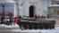 People pass by the entrance to St. Michael Cathedral, with a damaged Russian military vehicle in the foreground, in central Kyiv, Ukraine, Dec. 12, 2022. 