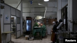 FILE - Doctors treat an injured civilian in a field hospital after what activists said was shelling by forces of Syria's President Bashar al-Assad in the Douma neighbourhood of Damascus, Eastern Ghouta, Syria November 19, 2015.