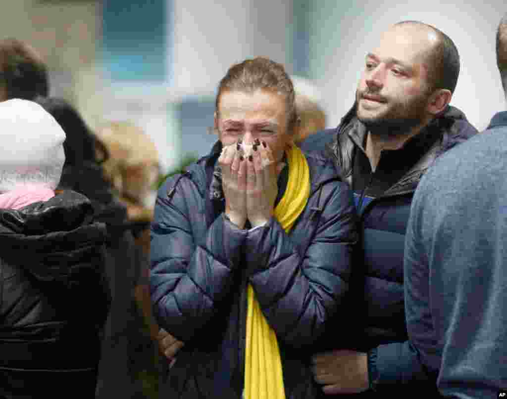 A stewardess with Ukrainian air-line reacts, near to coffins of the flight crew members of the Boeing 737-800 plane that crashed on the outskirts of Tehran, during a memorial service at Borispil international airport outside Kyiv, Ukraine.