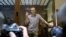 Russian opposition leader Alexey Navalny gestures as he posed for photographers standing in a glass enclosure at the Babuskinsky District Court in Moscow, Russia, Feb. 20, 2021. 