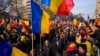 Protesters walk holding Romanian flags during a rally calling for free elections after Romania' s Constitutional Court annulled the first round of presidential elections, in Bucharest, Jan.12, 2025. 