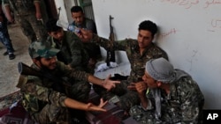 U.S.-backed Syrian Democratic Forces fighters talk to each other at their position where they were battling Islamic State militants, on the front line on the western side of Raqqa, northeast Syria, July 17, 2017.