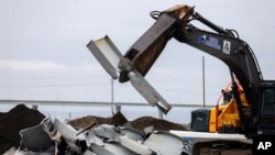 Un esquilador rompe piezas recuperadas del puente Francis Scott Key colapsado en Tradepoint Atlantic, el viernes 12 de abril de 2024, en Sparrows Point, Maryland.