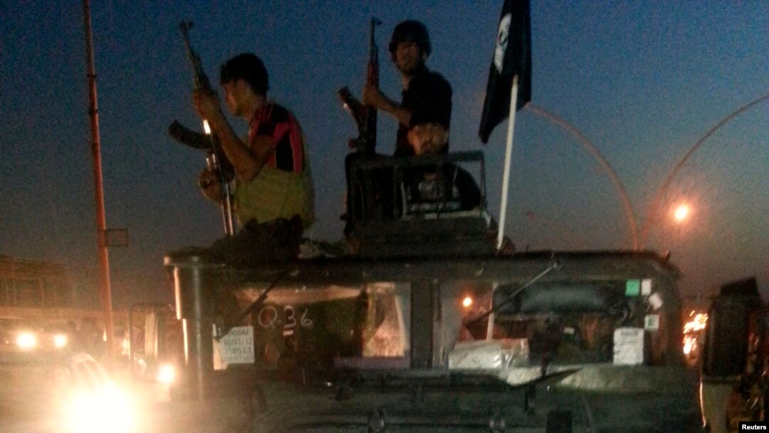 FILE - Islamic State display their flag during celebrations in Mosul, Iraq.