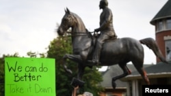 Protesters gather below a monument dedicated to Confederate Major John B. Castleman while demanding that it be removed from the public square in Louisville, Ky., Aug. 14, 2017. 