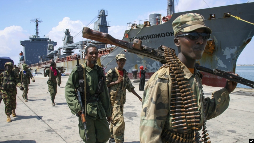 Somali National Army soldiers and pro-government Ras Kamboni brigadiers walk along seaport quay, Kismayo, Nov. 2, 2012.