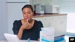 In this undated handout photo provided by Orasure, a model demonstrates the OraQuick test, which detects the presence of HIV in saliva collected using a mouth swab. The test is designed to return a result within 20 to 40 minutes. 