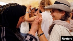 Women celebrate inside a "peace tent" erected as part of an event organized by "Women Wage Peace" group calling for an end to the Israeli-Palestinian conflict, near the Jordan River, in the occupied West Bank, Oct. 8, 2017.