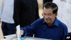 Cambodian Prime Minister Hun Sen of the Cambodian People's Party (CPP) drops a ballot into a box for voting at a polling station at Takhmua in Kandal province, southeast Phnom Penh, Cambodia