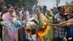 Activists from India's main opposition Bharatiya Janata Party (BJP) burn an effigy representing chief of ruling Congress Party Sonia Gandhi during a protest in Noida, Uttar Pradesh on June 6, 2011.