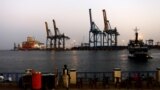 FILE - A man stands opposite the modern port at the harbor in Port Sudan at the Red Sea state, Feb. 24, 2014. 