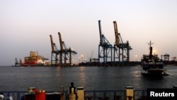 FILE - A man stands opposite the modern port at the harbor in Port Sudan at the Red Sea state, Feb. 24, 2014. 