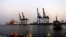 FILE - A man stands opposite the modern port at the harbor in Port Sudan, in Sudan's Red Sea state, Feb. 24, 2014. 