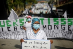 Un miembro del sindicato de trabajadores del ISSS sostiene una pancarta durante una protesta pidiendo medidas de cuarentena para contener la propagación de la enfermedad en El Salvador, 16 de julio 2020.