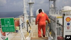 A Shell employee is seen aboard an oil vessel off the coast of Nigeria in this December 26, 2011 file photo.