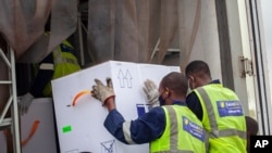 AstraZeneca COVID-19 vaccine doses are received by airport workers in Kigali, Rwanda, March 3, 2021. 
