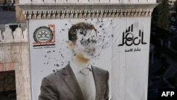 This aerial picture shows a bullet-riddled portrait of Syrian President Bashar al-Assad adorning Hama's municipality building after it was defaced following the capture of the city by anti government fighters, Dec. 6, 2024. 