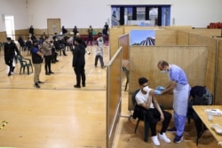 FILE - A man receives a dose of the AstraZeneca vaccine, at a makeshift vaccination site at Baitul Futuh Mosque, in London, Britain, March 28, 2021.