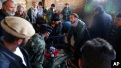 Familiares rodean el cuerpo de un niño muerto en un ataque con cohetes en Kabul, Afganistán, el sábado 21 de noviembre de 2020. El grupo Estado Islámico se atribuyó el ataque.