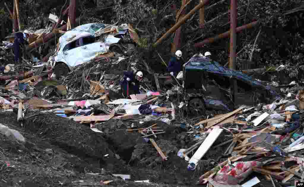 Petugas pemadam kebakaran melakukan pencarian korban setelah bencana tanah longsor akibat topan Wipha mengubur rumah-rumah warga di pulau Oshima, 120 km sebelah selatan Tokyo, Jepang.