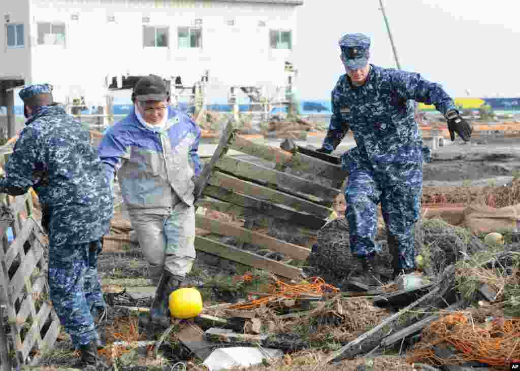 U.S. sailors help remove debris during a cleanup effort at Japan's Misawa Fishing Port on March 14, 2011. (US NAVY)
