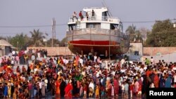 Watu wakusanyika pembeni ya mto Shitalakshya, ambako feri ya kubeba abiria imezama baada ya kugongana na meli ya mizigo mjini Narayanganj (Picha na Reuters)