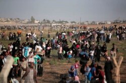 FILE - Thousands of Syrian refugees cross into Turkey, in Akcakale, Sanliurfa province, June 14, 2015.