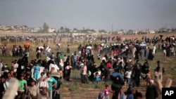 FILE - In this June 14, 2015 file photo taken from the Turkish side of the border between Turkey and Syria, in Akcakale, Sanliurfa province, southeastern Turkey, thousands of Syrian refugees walk in order to cross into Turkey. 
