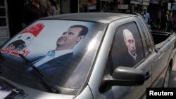 FILE - A poster of Syria's President Bashar al-Assad (L) and a photo of Russian President Vladimir Putin are seen on a car near Latakia, Syria, May 26, 2014.