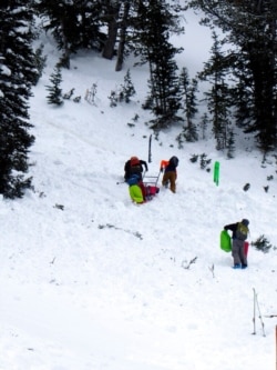 This aerial photo provided by Gallatin National Forest Avalanche Center shows a ground team approaching the area of an avalanche in the Gallatin National Forest, Mont., Feb. 14, 2021.