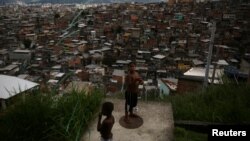 FILE - A boy flies a kite at the Complexo do Alemao slum in Rio de Janeiro, Brazil, Feb. 24, 2018. 