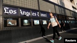 People walk by the Los Angeles Times building in Los Angeles, Feb. 6, 2018.