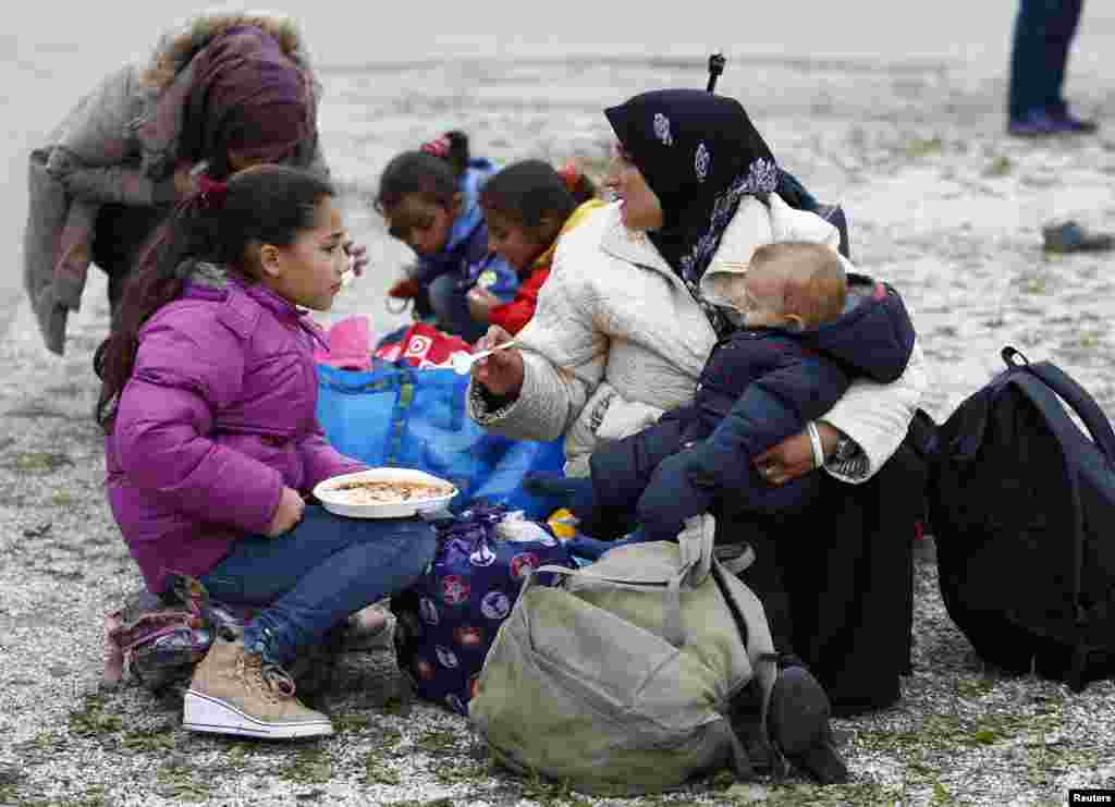 Migrants eat outside a makeshift refugee camp at the fair ground of Munich, Germany, Sept. 7, 2015.