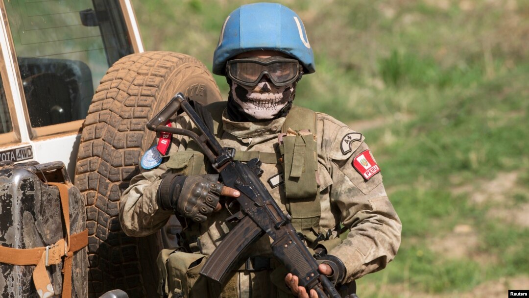 FILE - A United Nations peacekeeping soldier provides security during a food aid delivery by the United Nations Office for the Coordination of Humanitarian Affairs and world food program in the village of Makunzi Wali, Central African Republic, April 27. 