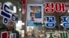 FILE - Restaurant owner Shin Byung-chul looks from behind a flyer he put up of Kenneth Barthel, who was abandoned in the area as a child and later adopted to Hawaii at 6 years old, at his restaurant in Busan, South Korea, May 17, 2024.